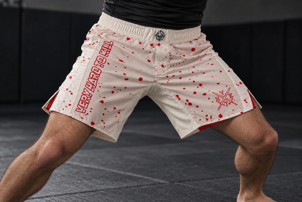 Athlete wearing VHTK Killshot grappling shorts in a wide stance, showing the off-white inner thigh panel, split side vents and red splatter artwork.