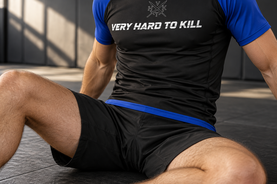 VHTK Blue Rankings rash guard covering the waist in a seated guard position.