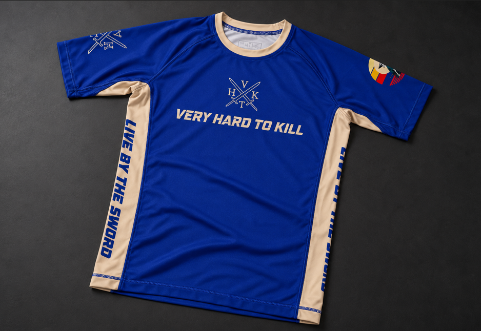 Front view of the VHTK Blue Samurai rash guard with cream side panels and chest branding on a charcoal background.