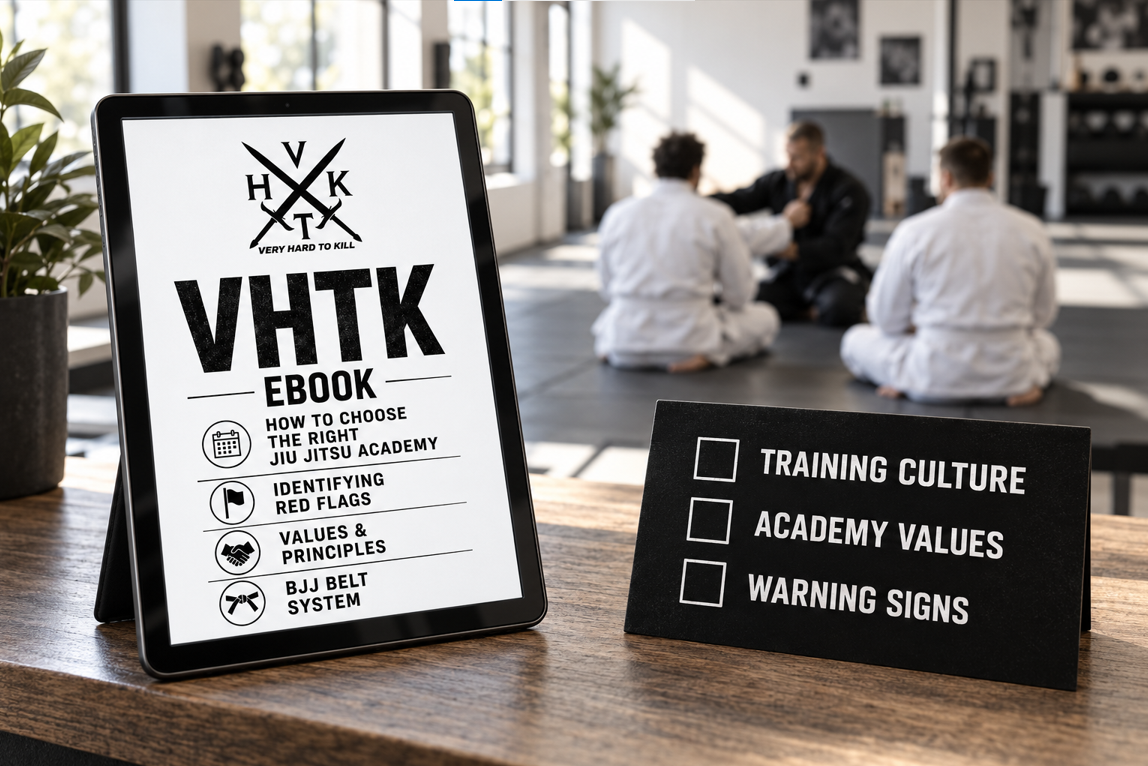 VHTK BJJ gym selection ebook on a tablet beside a training culture checklist, with an instructor and students blurred in the background.