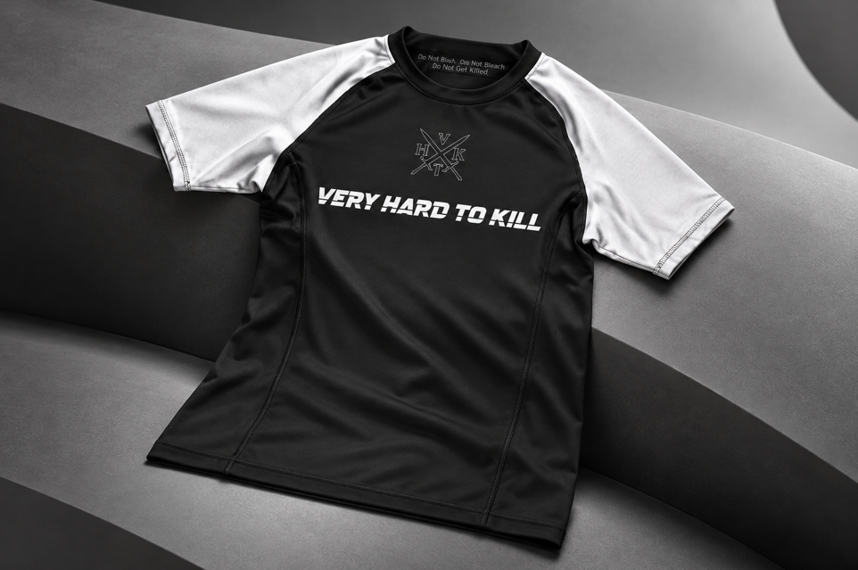VHTK White Rankings rash guard draped across a curved grey studio surface.